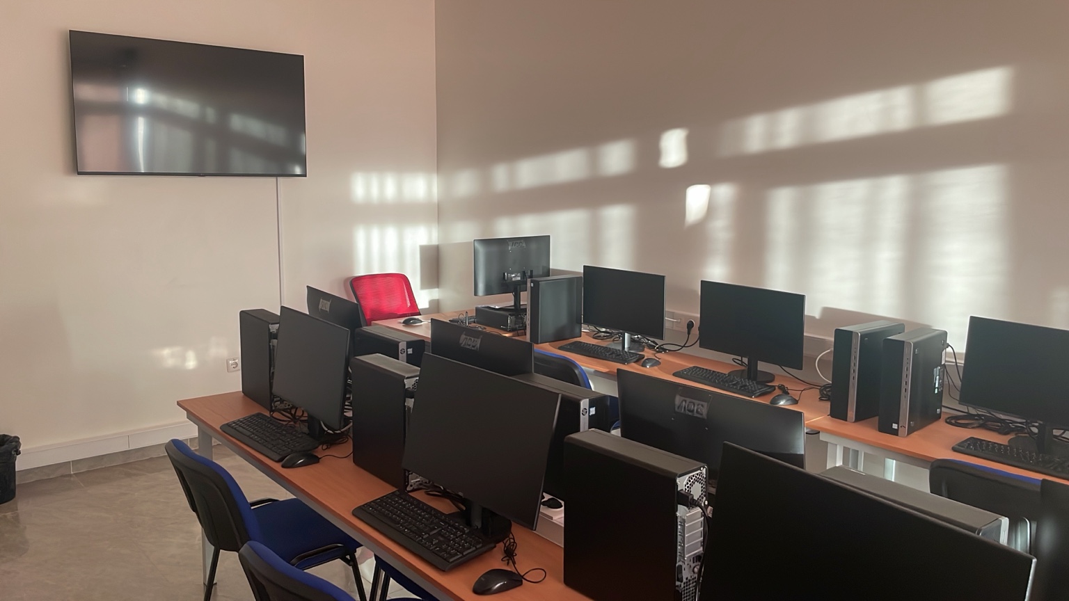 Sala de formação equipada com computadores, mesas e cadeiras